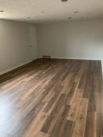Wood-finish flooring, recessed ceiling lighting, and light-toned wall finishes