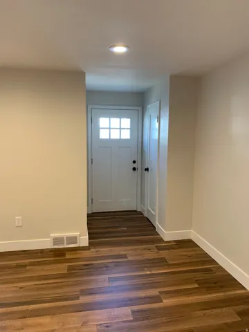 Entryway featuring a white paneled door with glass inserts, wood-finish flooring, recessed lighting, and a white interior door