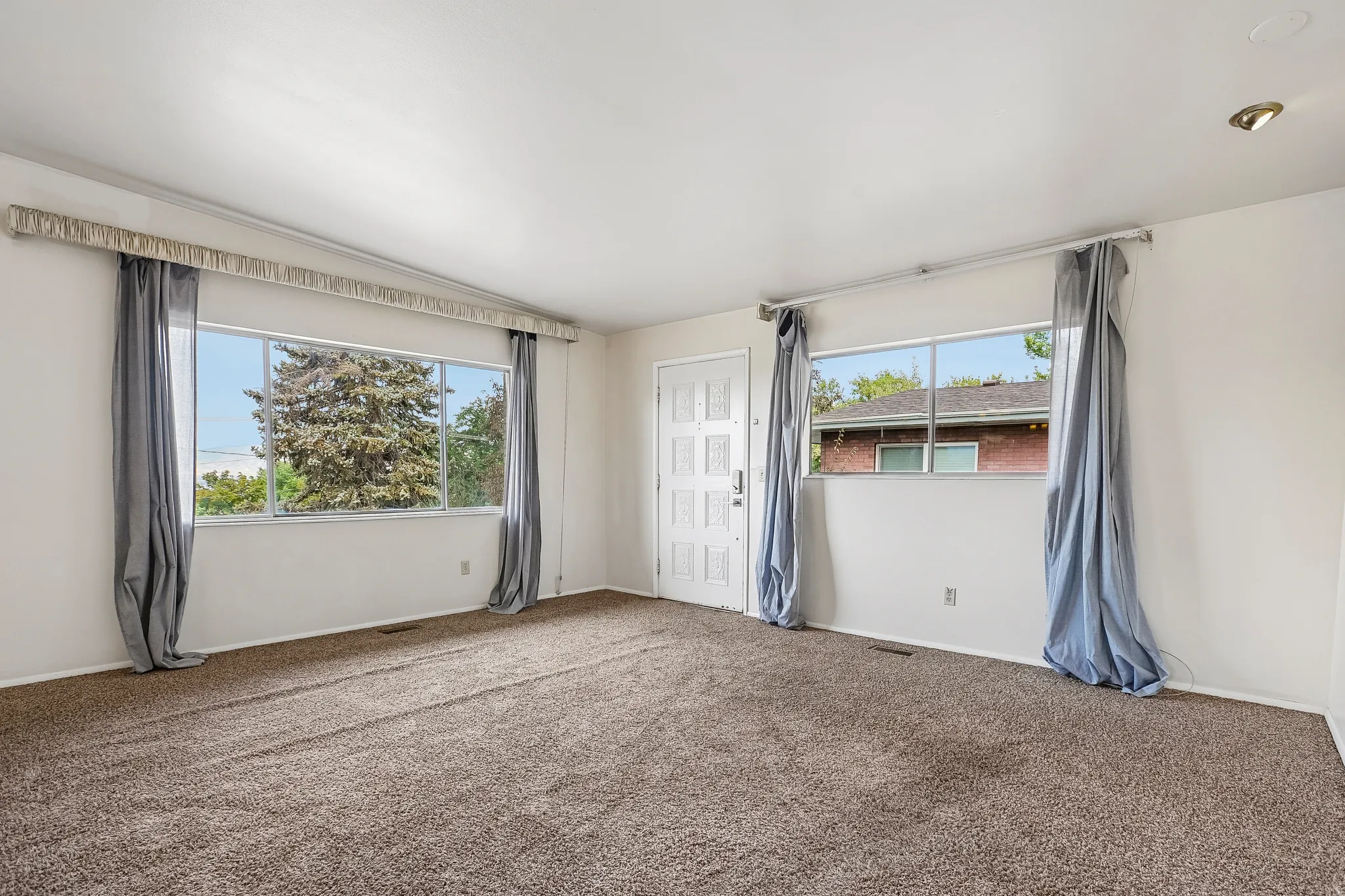 White painted walls, recessed lighting, and a paneled entry door