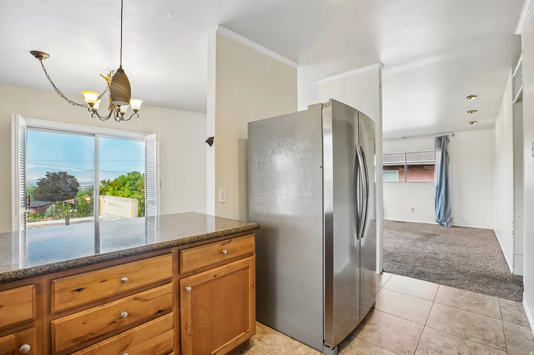 Kitchen featuring wood cabinetry, a granite-finish countertop, stainless steel refrigerator, and recessed lighting