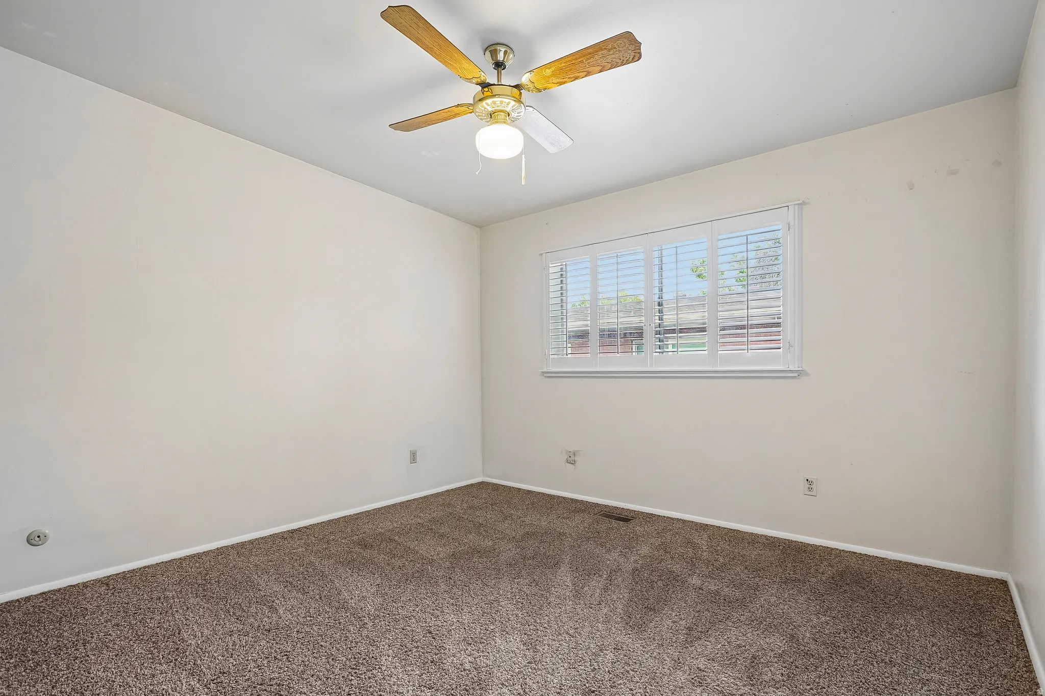 Neutral wall finishes, textured carpeting, window with slatted blinds, and ceiling fan with integrated lighting