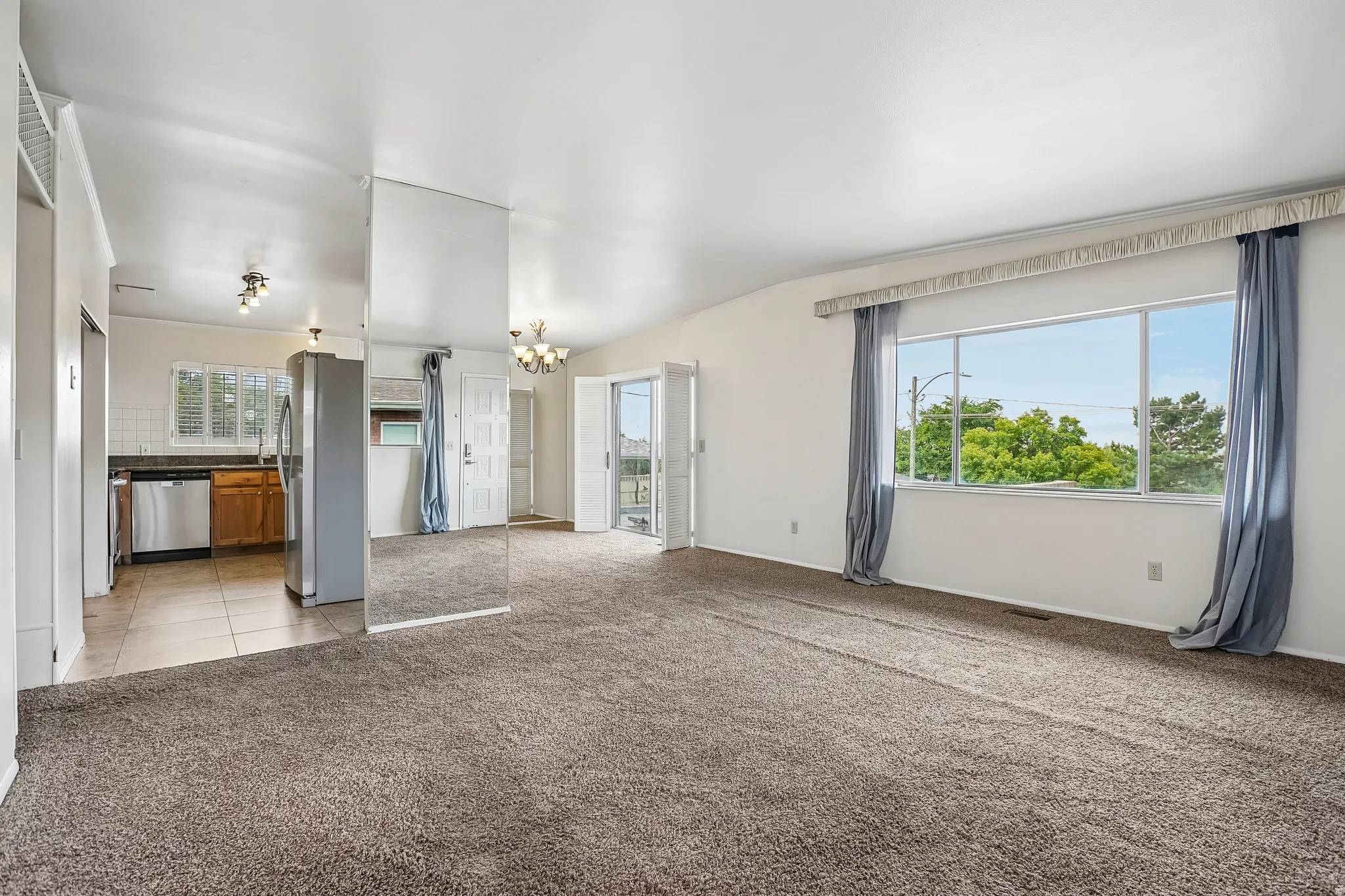 Open-concept living space with carpet flooring and expansive windows