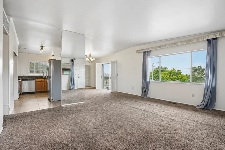 Open-concept living space with carpet flooring and expansive windows