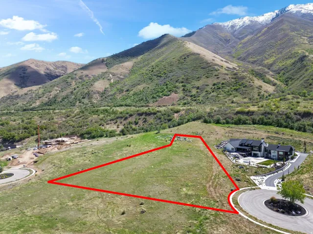 Expansive land parcel featuring natural terrain and a paved cul-de-sac