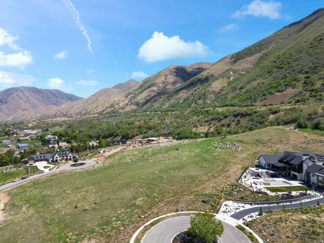 Expansive land parcel featuring natural terrain and a backdrop of mountainous scenery