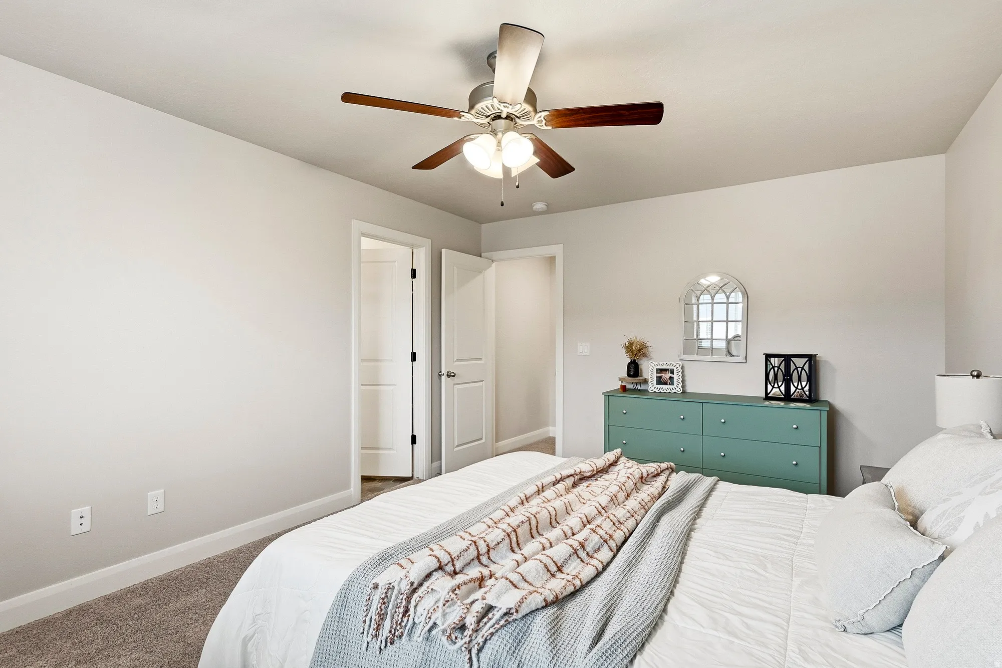 Neutral wall color, ceiling fan with light fixture, white interior doors, and carpeted flooring