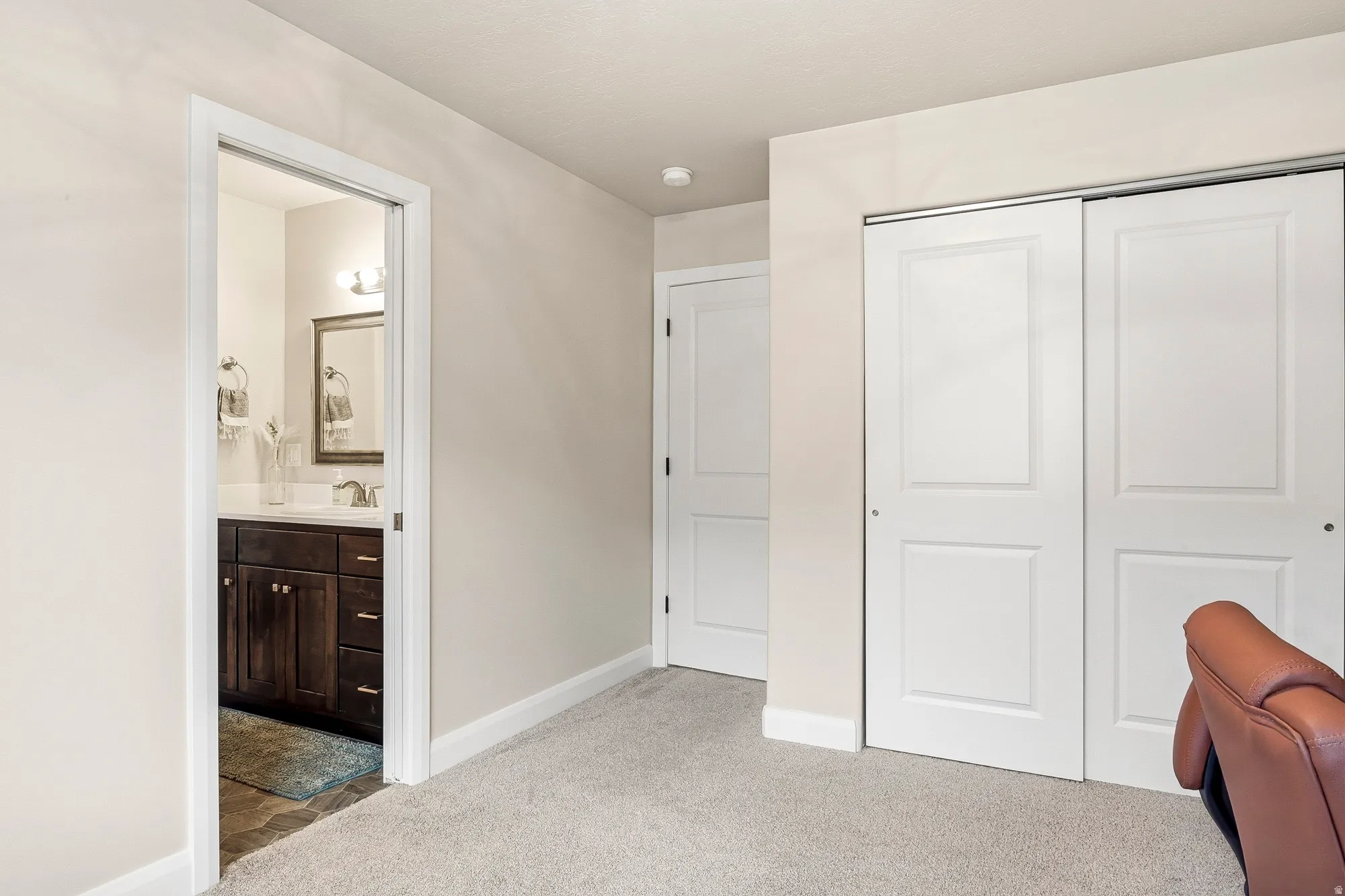 Carpeted flooring, white trim, two-panel sliding closet doors, and recessed lighting