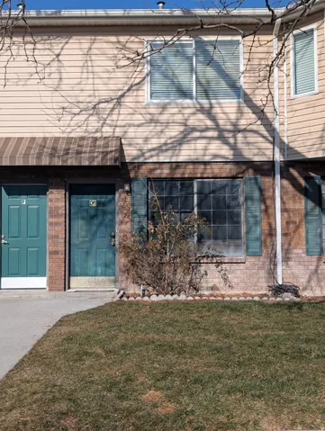 Beige horizontal siding exterior with a brick-finish lower level
