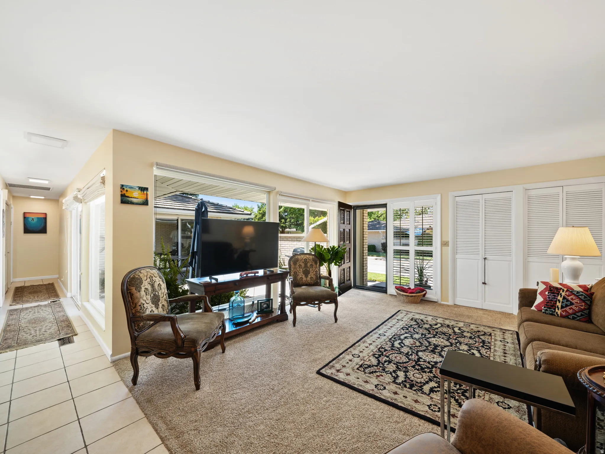 Light-toned walls complement the carpeted living area and tiled hallway