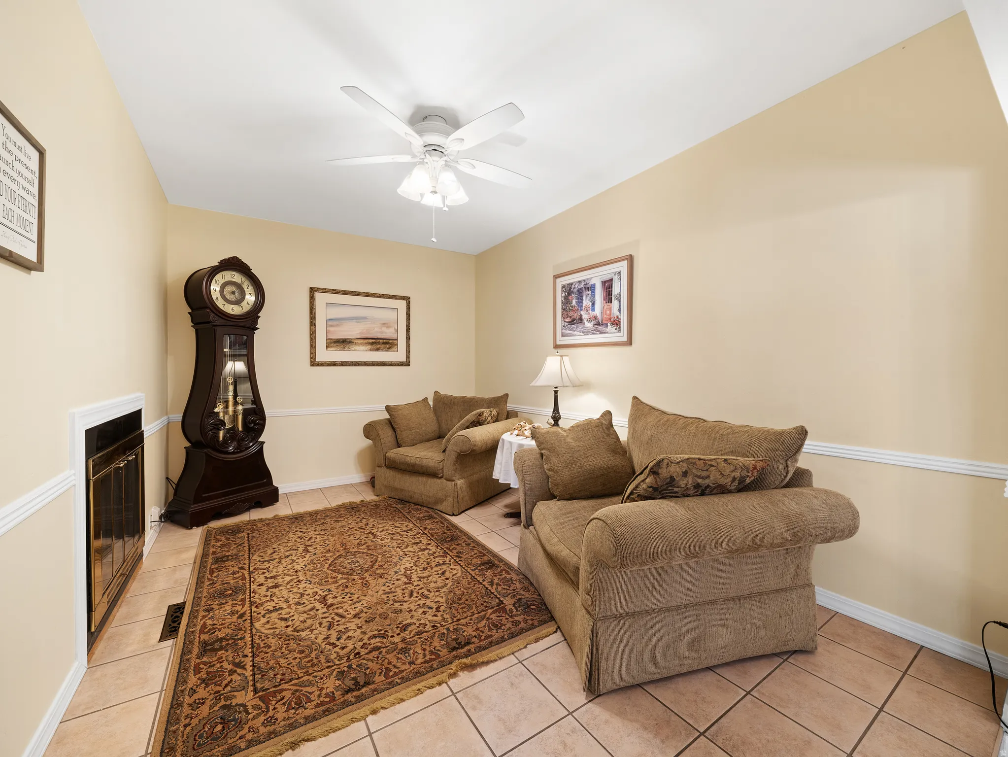 Recessed fireplace with a white trim surround, tile flooring, and a ceiling fan with light fixture