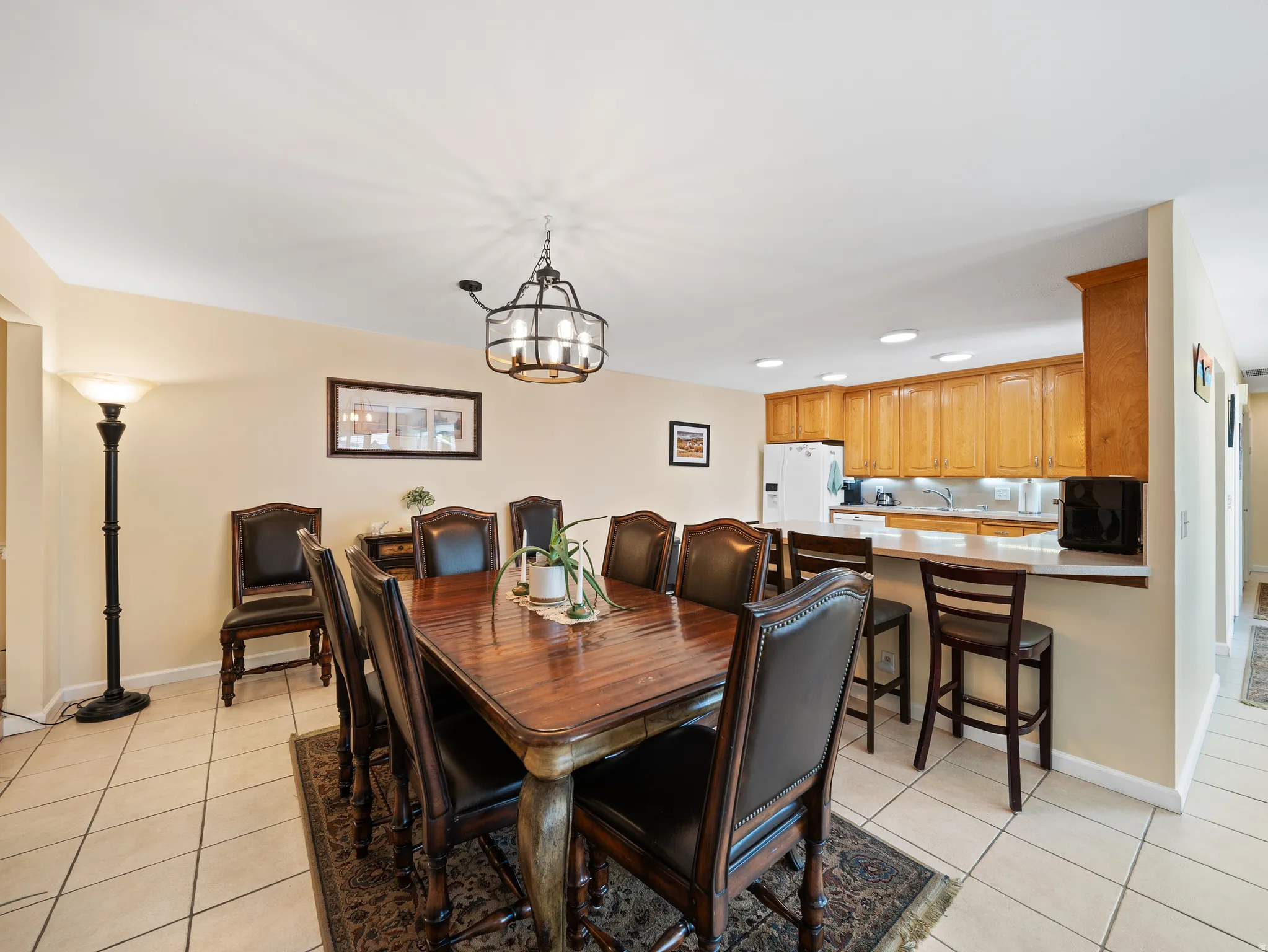 Tile flooring, overhead lighting, kitchen with wood cabinetry, white countertops, and recessed lighting