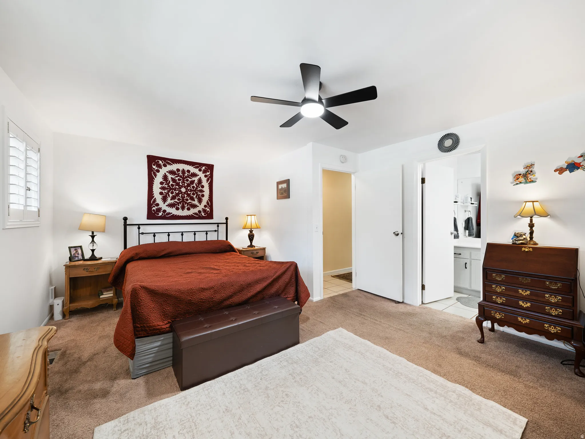 Neutral color palette with carpet flooring, a ceiling fan with integrated lighting, and a white plantation shutter window