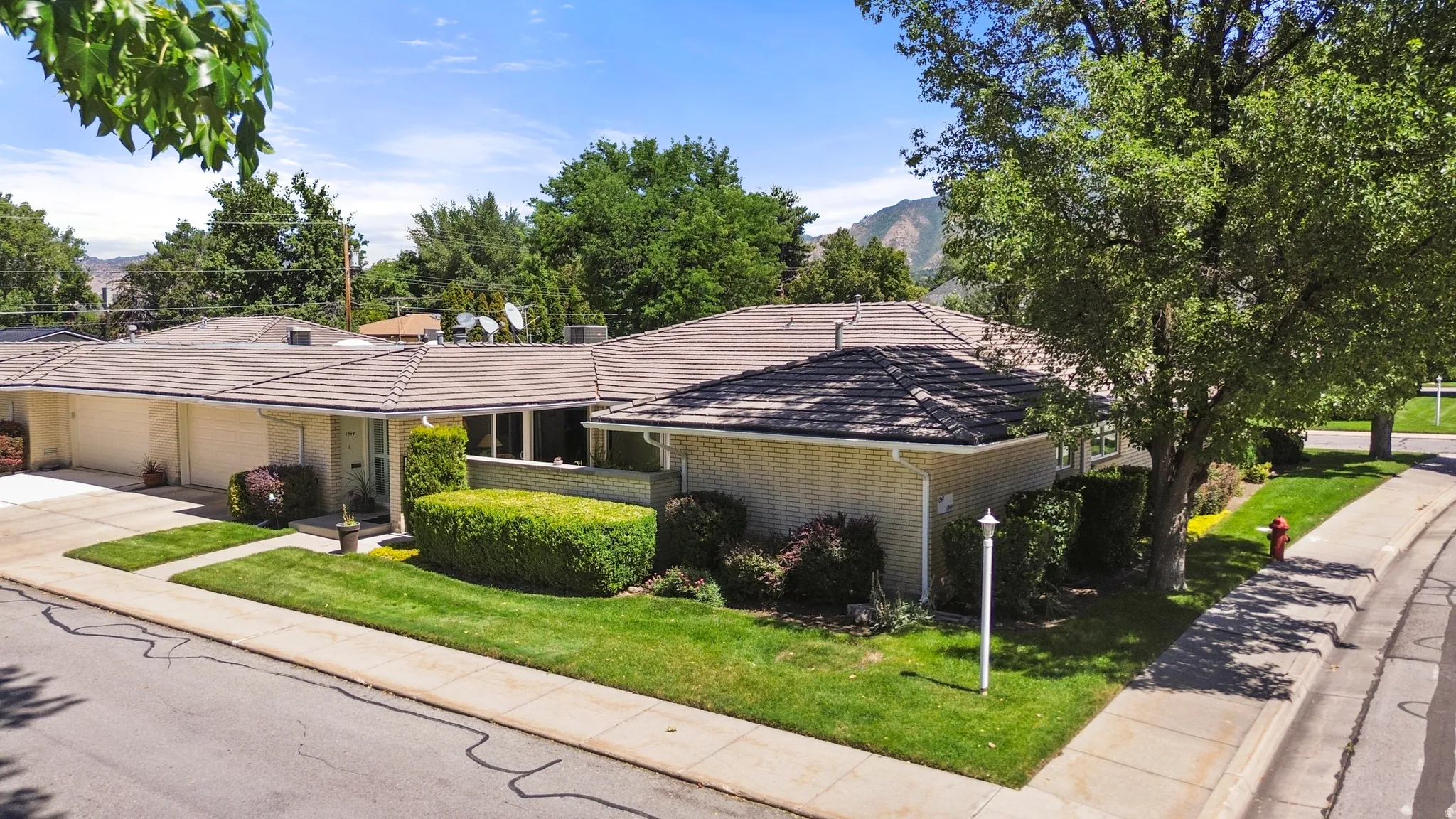 Single-story residence with a tiled roof, light-colored brick exterior, and a two-car garage