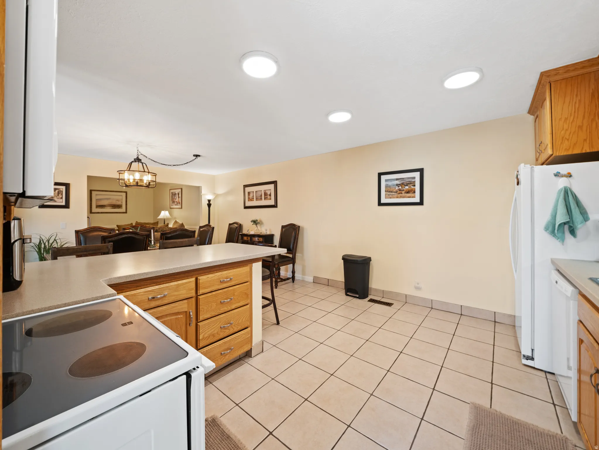 Spacious kitchen with tile flooring, wood cabinetry, and a countertop island with seating