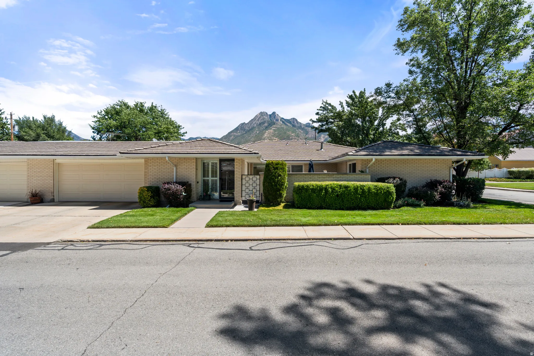 Brick exterior with a gabled roof, attached garage, and a concrete driveway