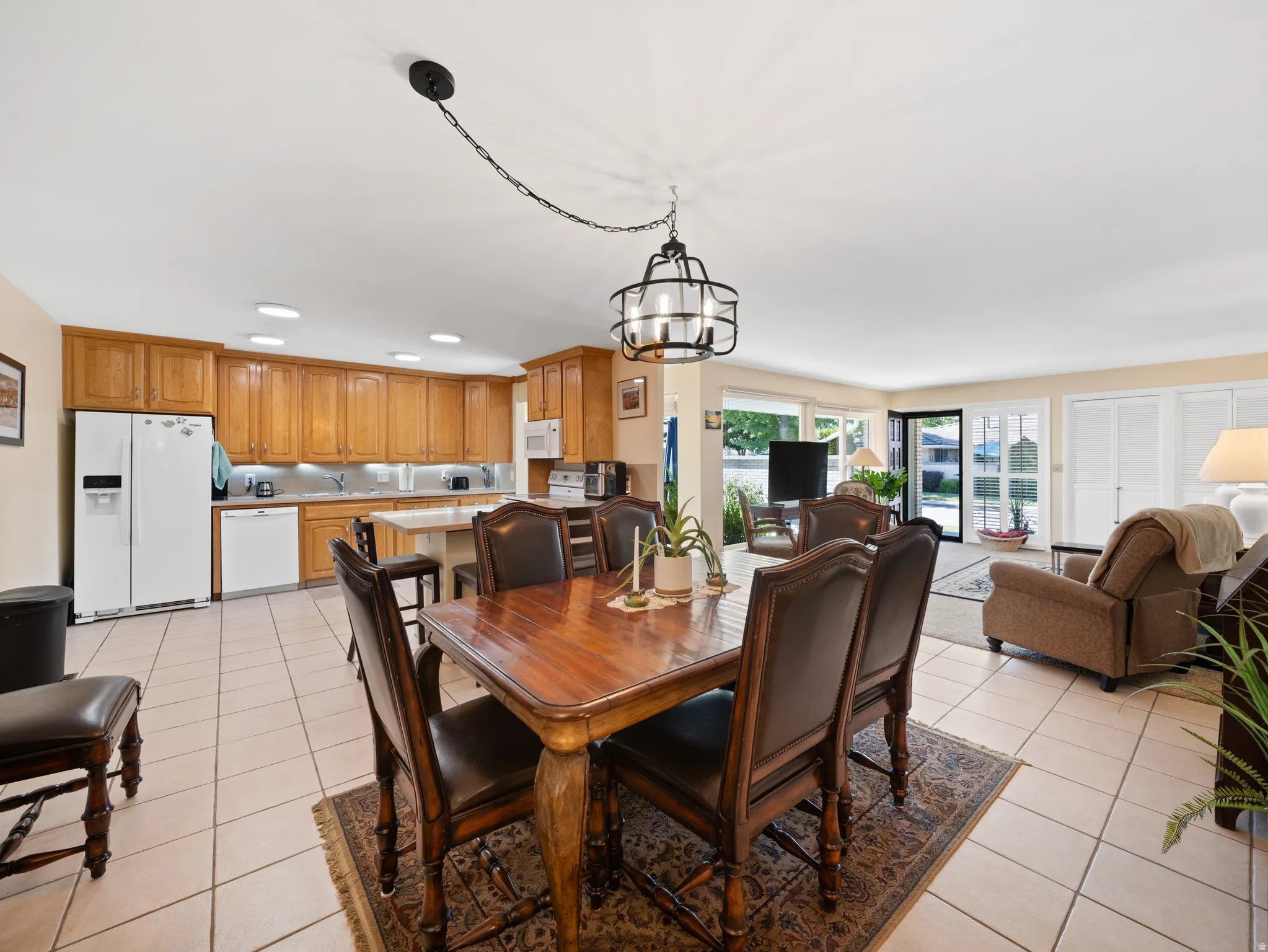 Open-concept living space with tile flooring, recessed lighting, wood cabinetry, and a kitchen island