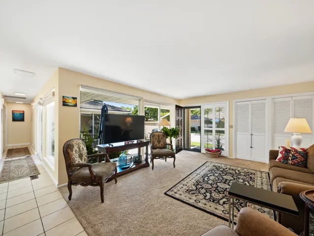 Light-toned walls complement the carpeted living area and tiled hallway