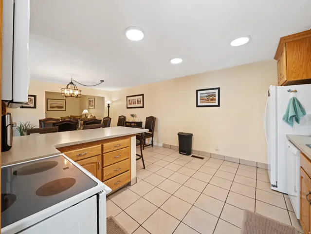 Spacious kitchen with tile flooring, wood cabinetry, and a countertop island with seating