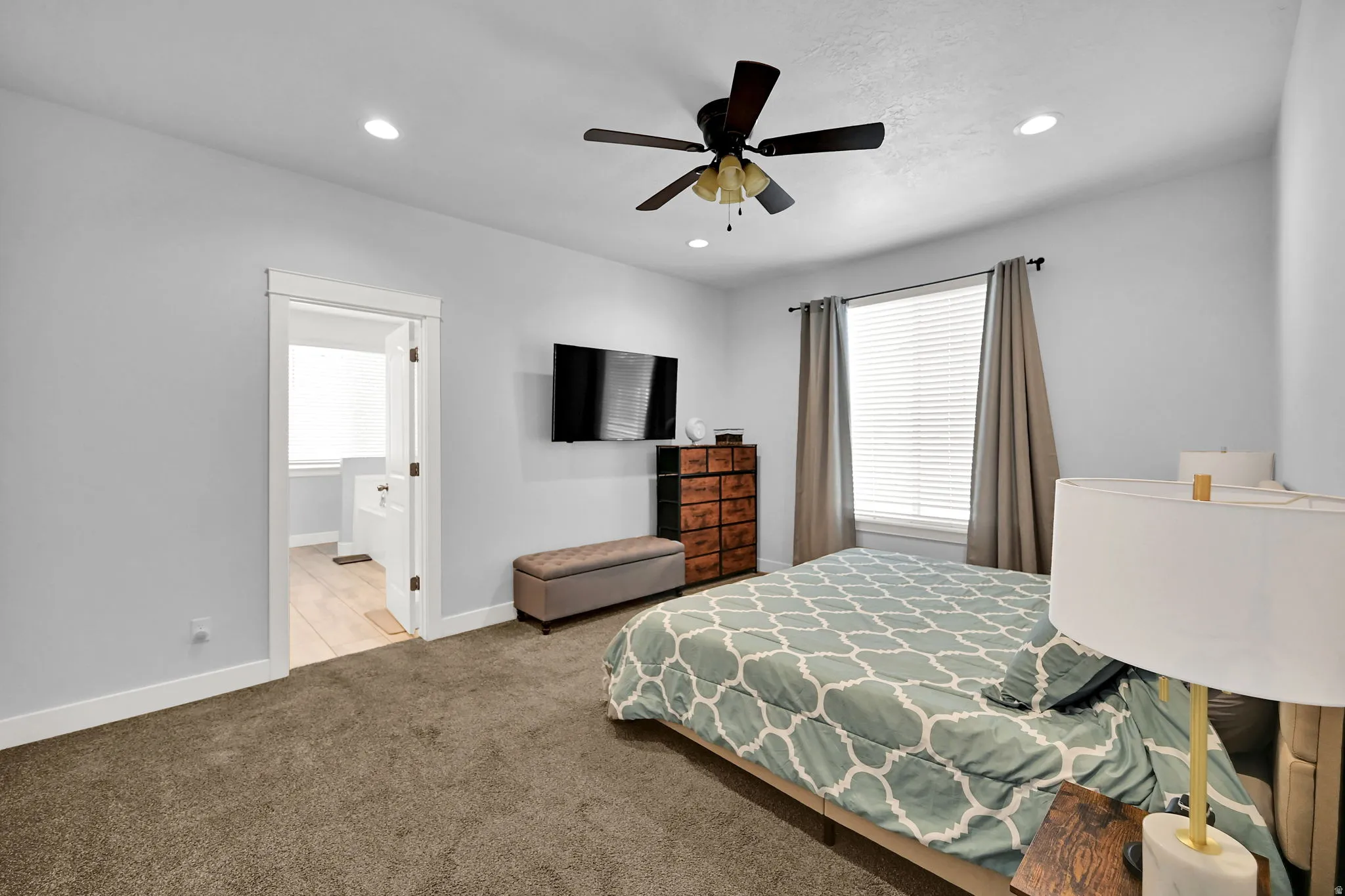 Recessed lighting, ceiling fan, carpet flooring, large window with blinds, and an entryway to another room