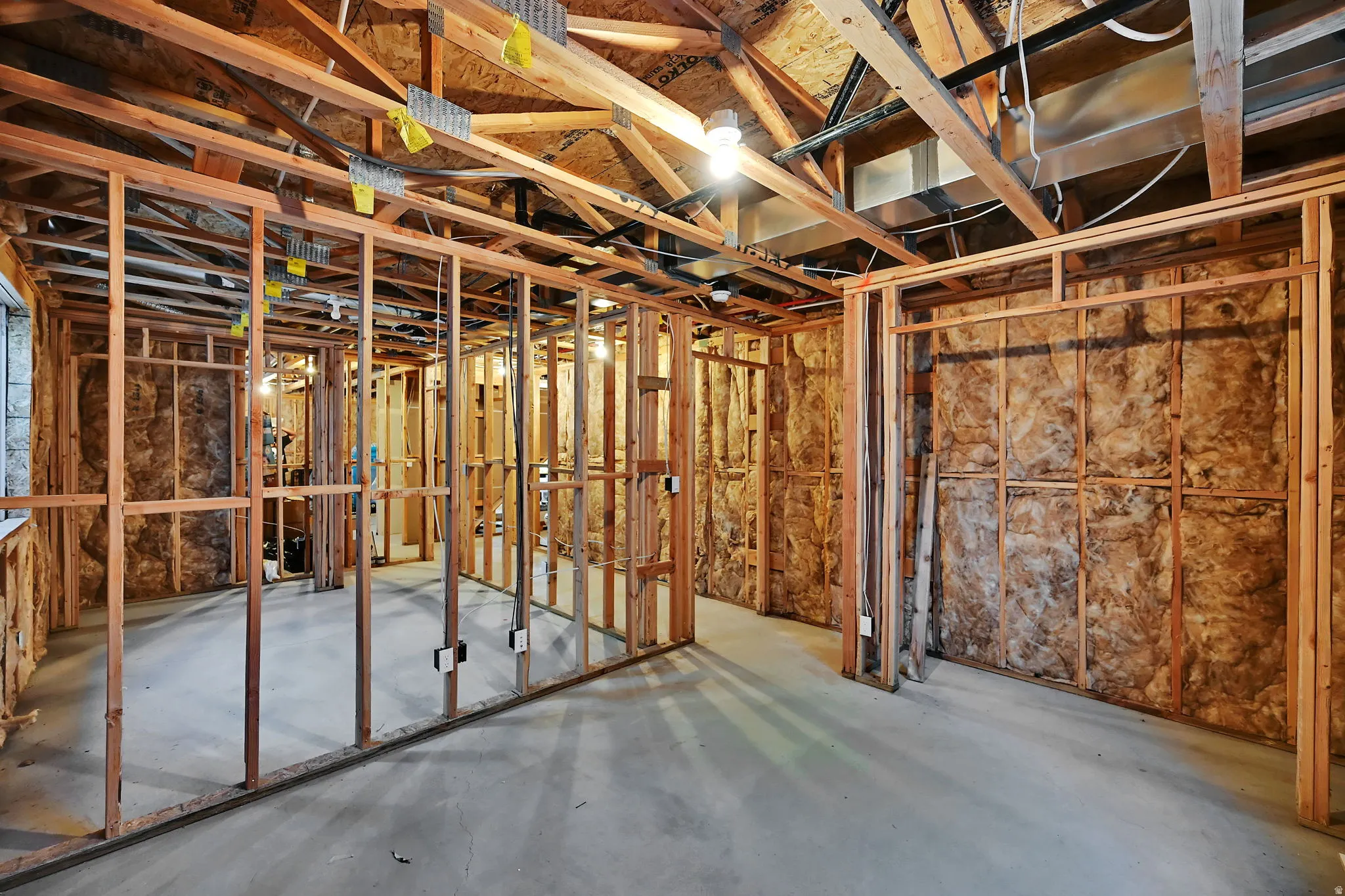Framed interior space with exposed ceiling joists and concrete flooring