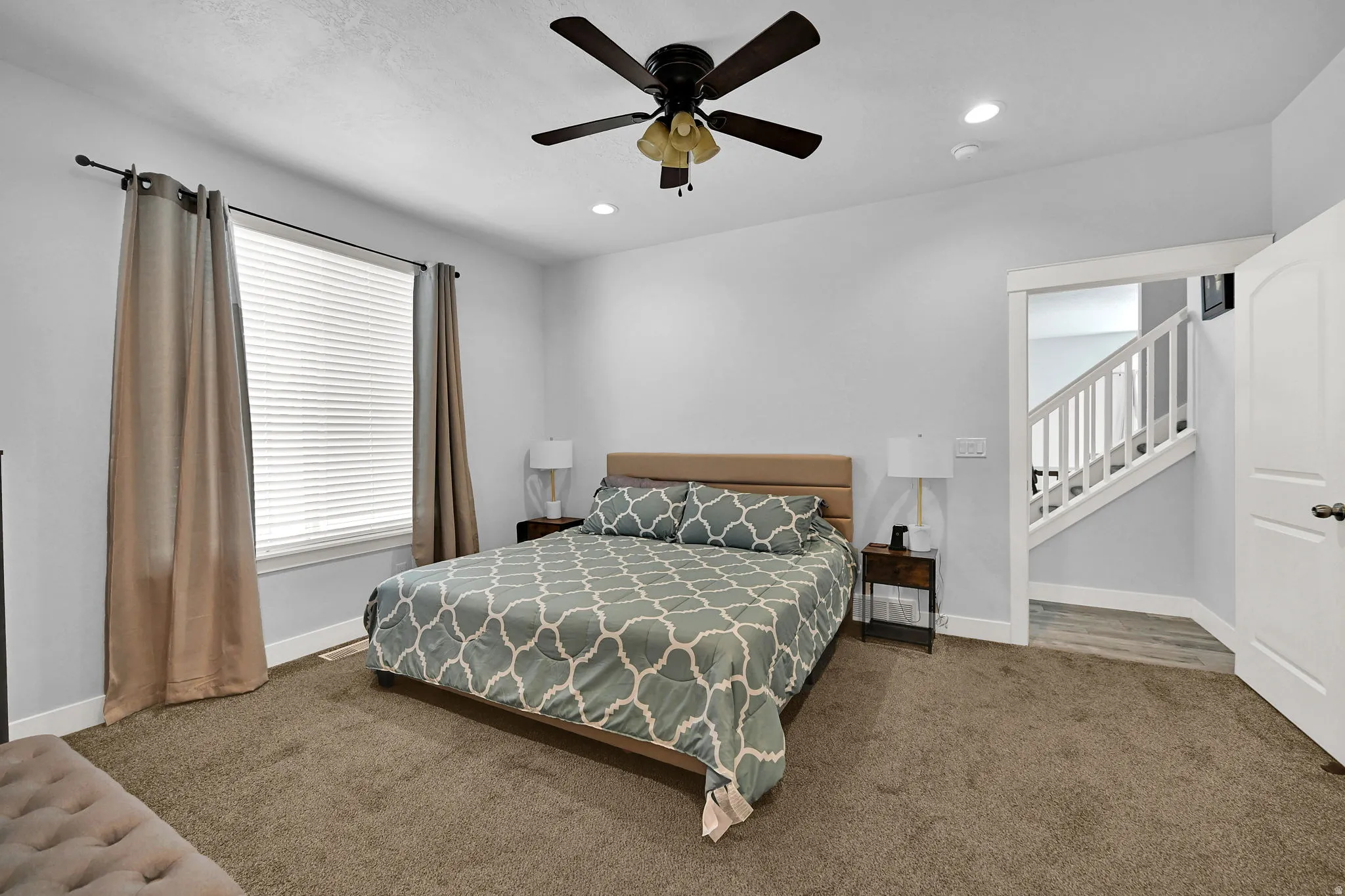 Carpeted room with a ceiling fan, recessed lighting, and a window featuring blinds