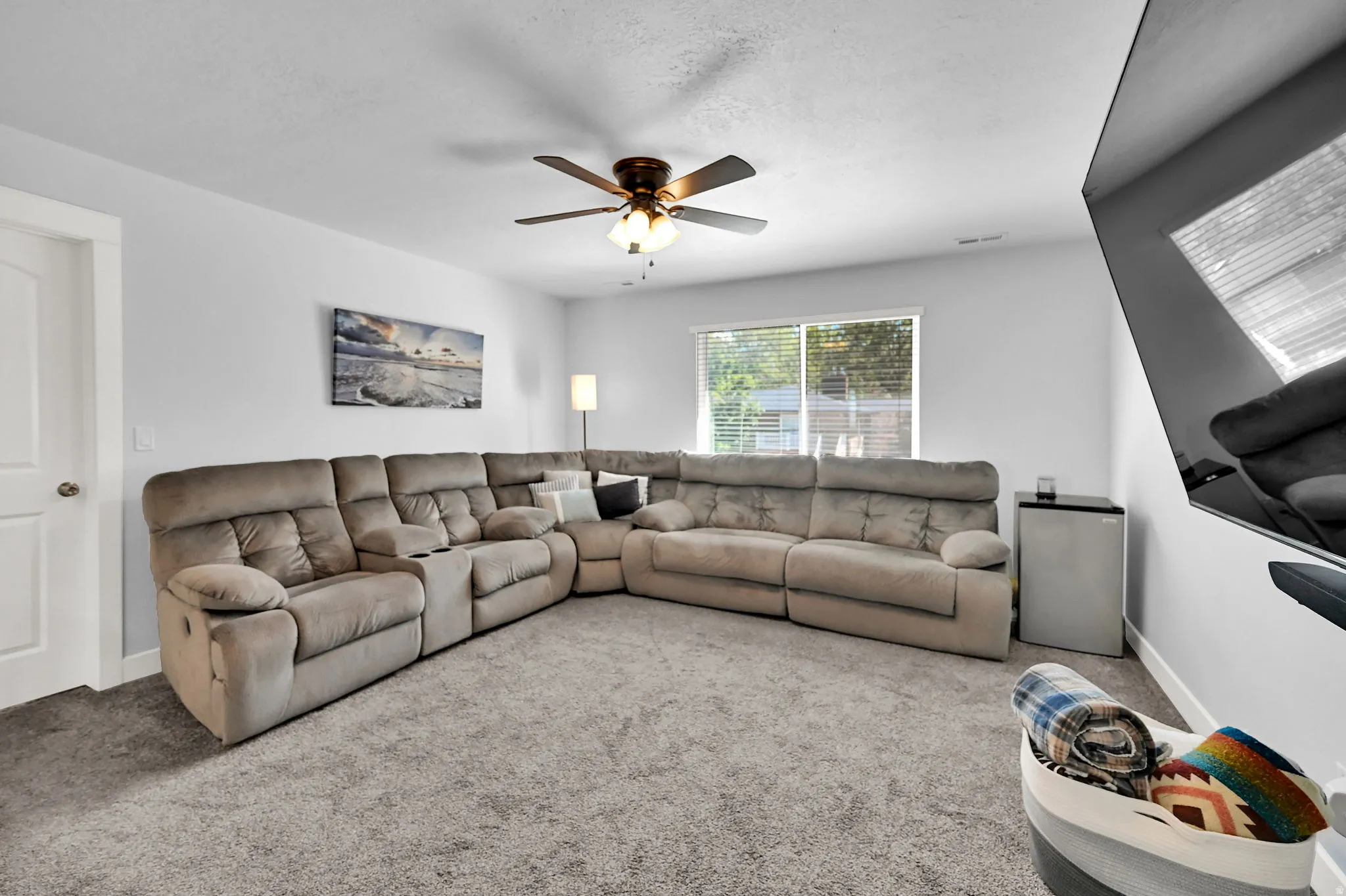 Recessed lighting, ceiling fan, white paneled door, light gray walls, and light-colored carpet flooring