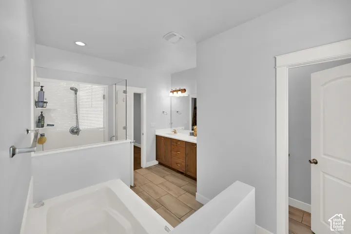 Soaking tub and glass-enclosed shower with white subway tile