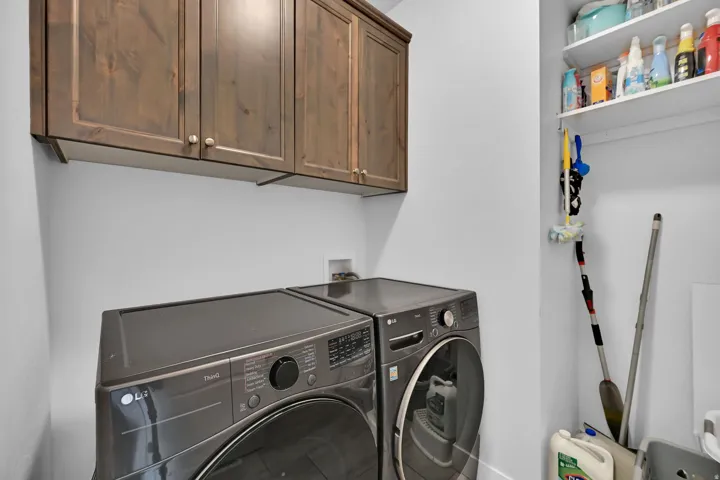 Built-in wooden cabinetry, white shelving, and a wall-mounted utility rack