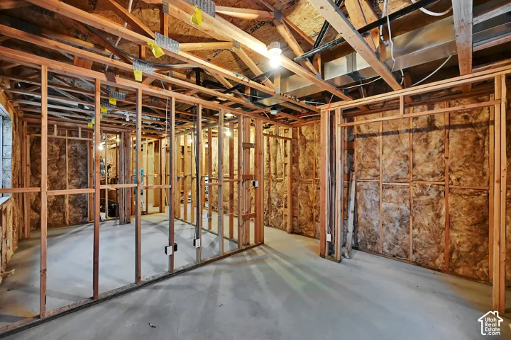 Framed interior space with exposed ceiling joists and concrete flooring