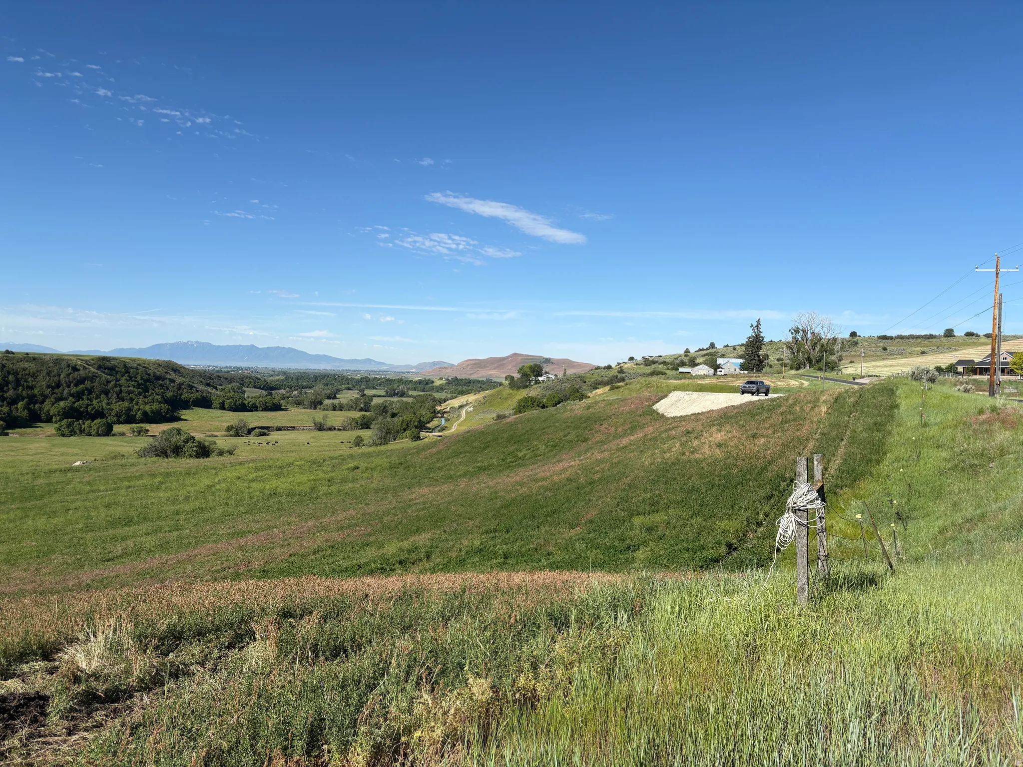 Expansive open landscape with rolling green hills and distant mountains