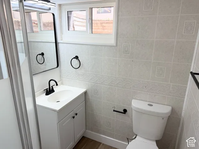 White vanity with matte black hardware, single white sink with matte black faucet, and rectangular black-framed mirror