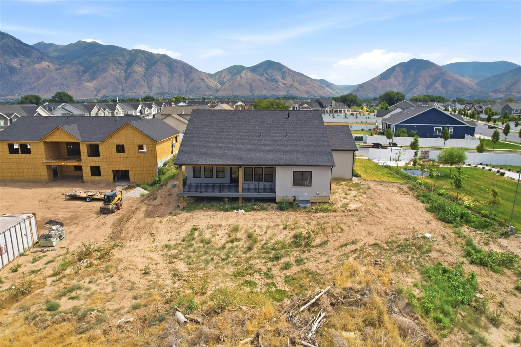 Rear exterior with a covered patio and mountain backdrop