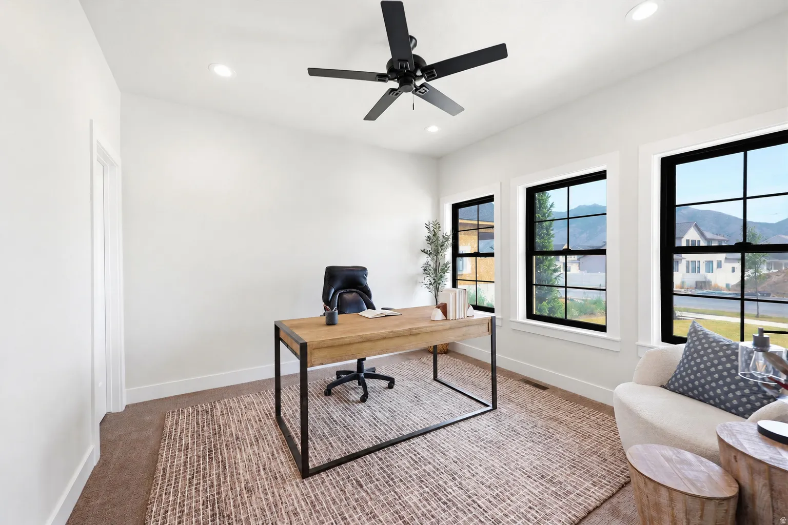 Recessed lighting, ceiling fan, multiple windows with black trim, and light wall finishes