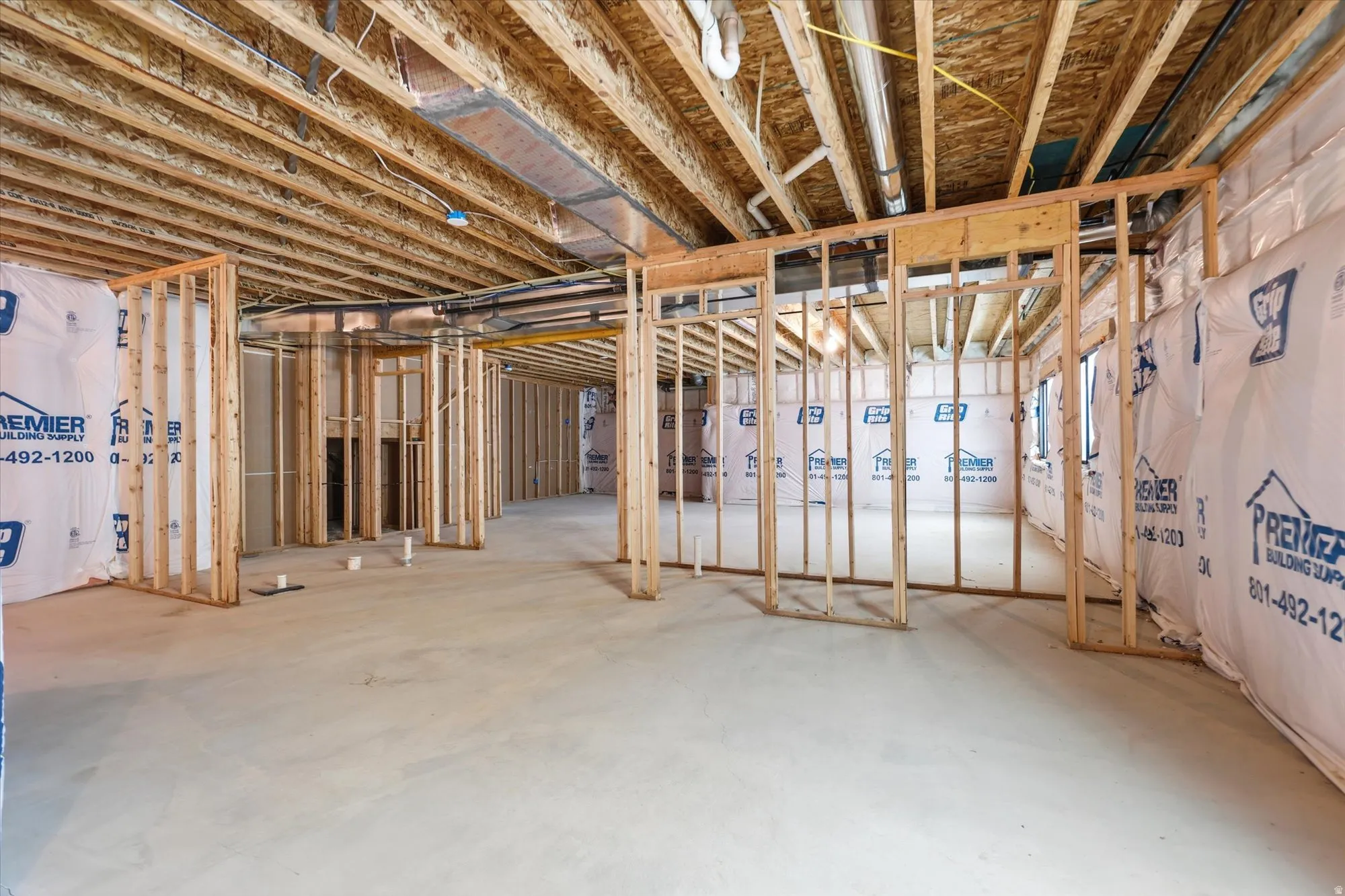 Unfinished basement featuring exposed wood framing, concrete flooring, and exposed ceiling joists