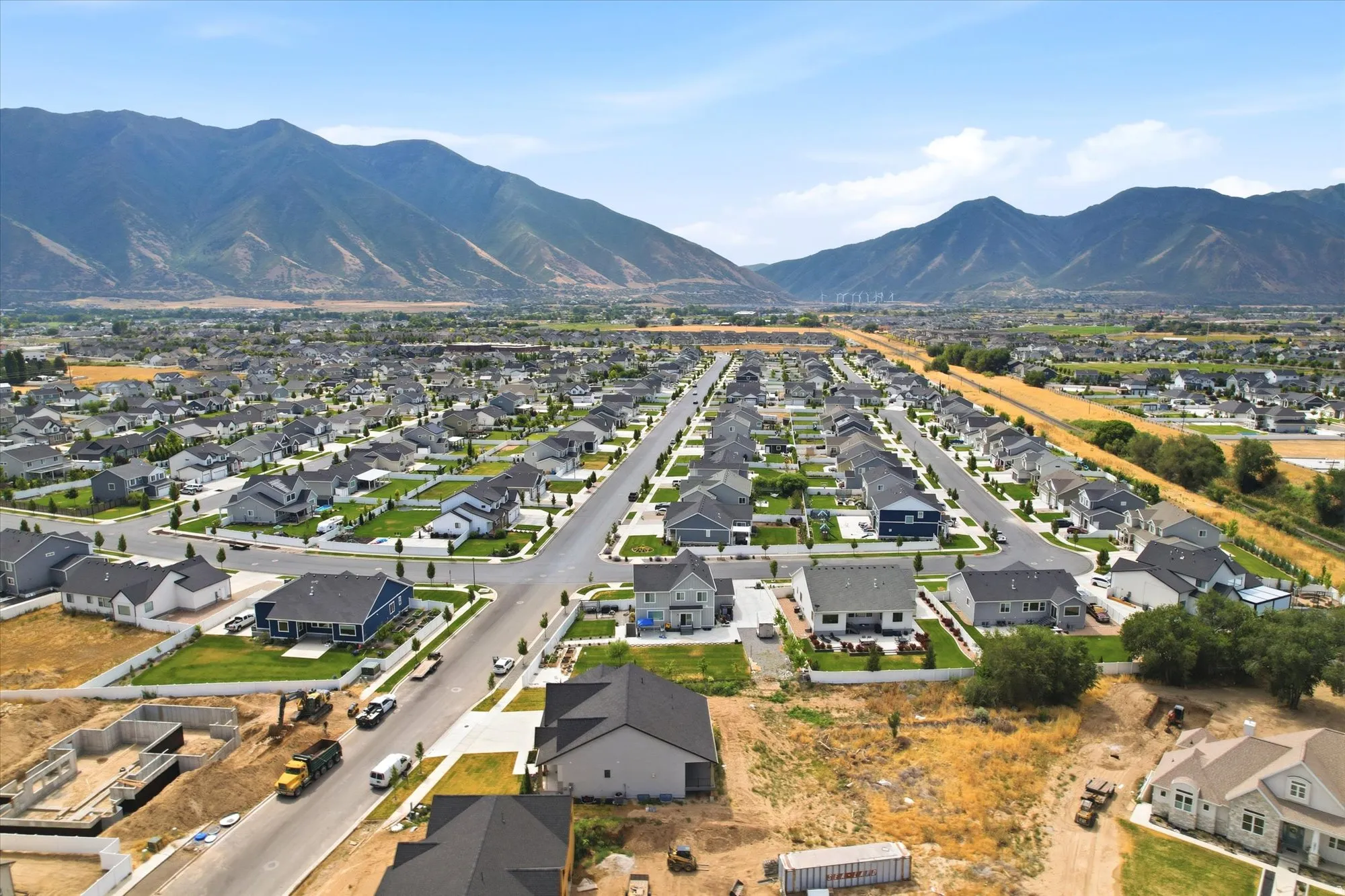 Expansive residential development featuring a mountain backdrop, established streets, and a mix of completed and under-construction homes