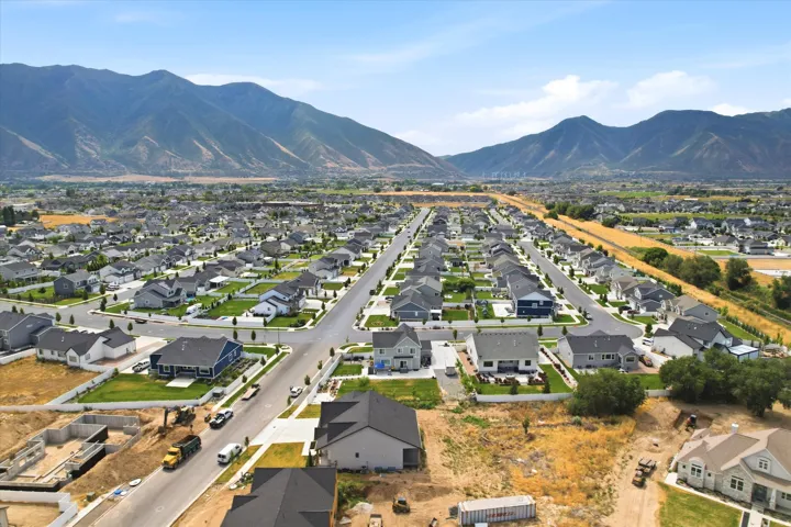 Expansive residential development featuring a mountain backdrop, established streets, and a mix of completed and under-construction homes