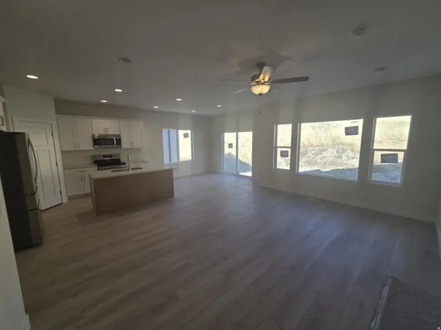 Open-concept living space featuring wood-finish flooring, recessed lighting, and a ceiling fan
