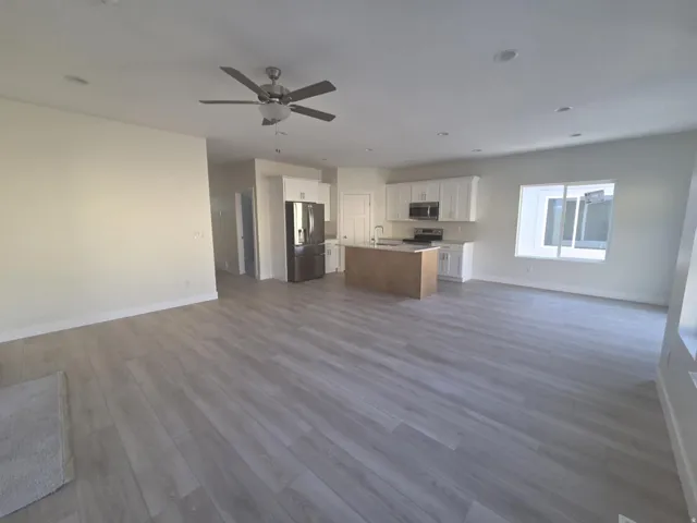 Open-concept living area featuring wood-finish flooring, recessed lighting, and a ceiling fan