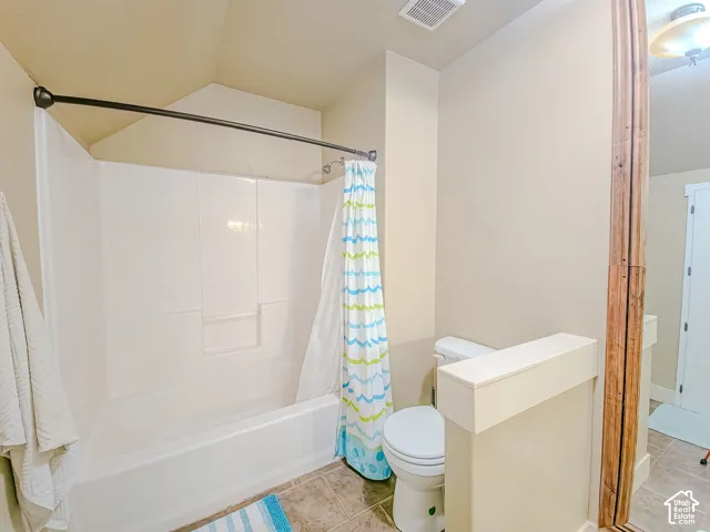 White tub and shower combination with a curved shower rod