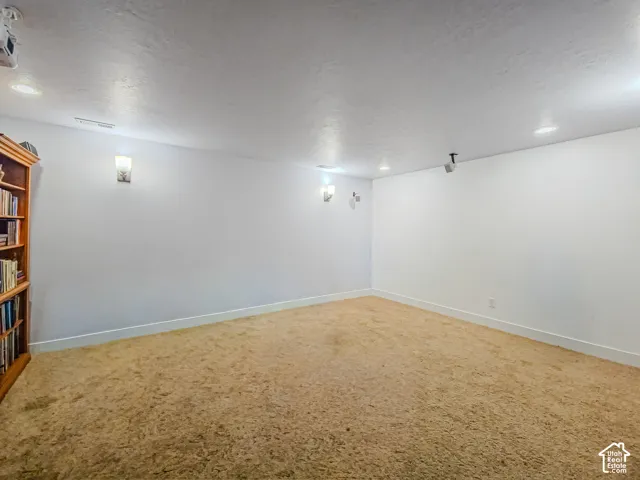 Spacious recreation room featuring cork flooring, recessed lighting, and fresh white walls