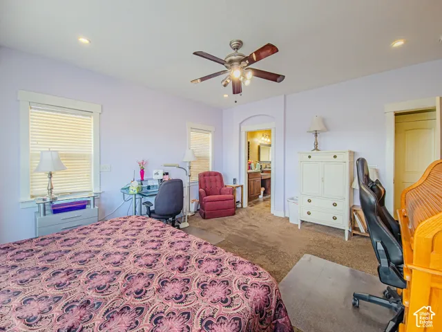 Ceiling fan with integrated lighting, recessed lighting, double windows with blinds, arched doorway, and solid panel door