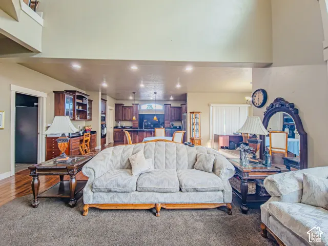 Open-concept living space with high ceilings, recessed lighting, and wood-finish flooring