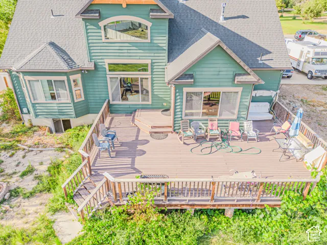 Multi-level deck with wood planking and wood railings, featuring multiple large windows and a bay window