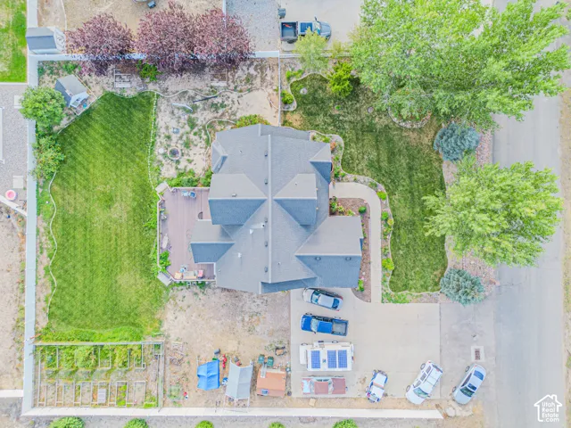 Expansive lot featuring a large lawn, mature trees, a multi-level deck, and a detached shed