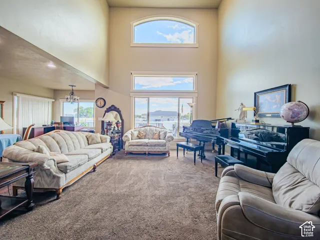 Two-story ceilings, arched window, expansive window wall, recessed lighting, and carpeted flooring