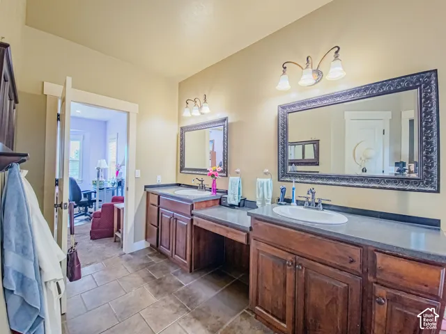 Dual vanity with wood cabinetry, integrated sinks, and broad countertops