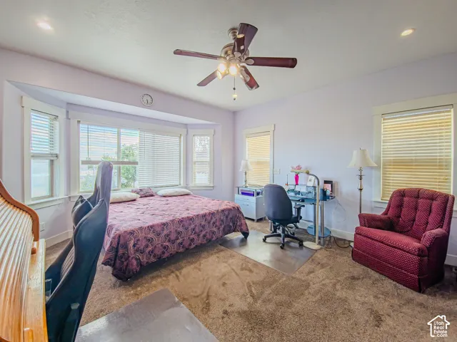 Recessed lighting, ceiling fan, bay window, light-colored walls, and carpet flooring