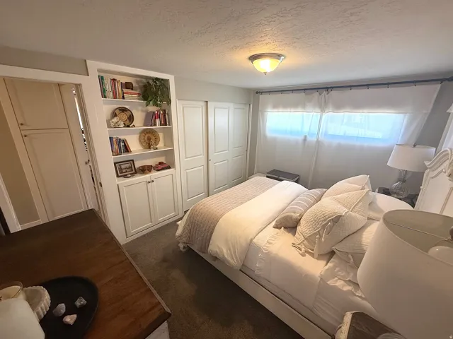 Built-in shelving, two-panel closet doors, and overhead lighting
