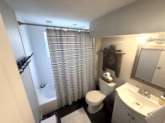 White vanity with integrated sink, chrome faucet, and rectangular framed mirror
