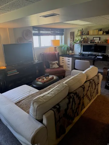 Recessed lighting, wood-finish shelving, built-in desk, and window with privacy blinds